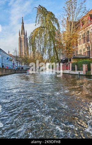 Bruges, Flanders, Belgium and the spire of the catholic Church of our Lady Bruges, (Onze Lieve Vrouw Brugge) towers above buildings in the city. Stock Photo
