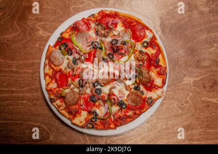 Delicious tomato sauce cheese covered hot and tasty supreme pizza pie Stock Photo