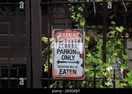 NEW YORK, NEW YORK - October 25, 2022: A warning sign is posted on a fence with other Halloween decorations outside a garden of a townhouse in New York City, New York, Tuesday, Oct. 25, 2022. (Photo: Gordon Donovan) Stock Photo