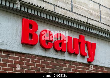Red sign at building storefront, Word is Beauty. Stock Photo