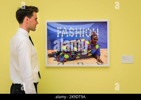 London, UK. 27th Oct, 2022. Staff pose with Ruth Ossai's 'Ebute Metta', 2018 (right). Invited guests and artists mingle and pose with the images. Private view of the new exhibition 'The New Black Vanguard: Photography Between Art and Fashion' at Saatchi Gallery in London, supported by Burberry. The exhibition features 15 international Black photographers and is a celebration of Black creativity both in-front of and behind the camera, running until Jan 22, 2023. Credit: Imageplotter/Alamy Live News Stock Photo