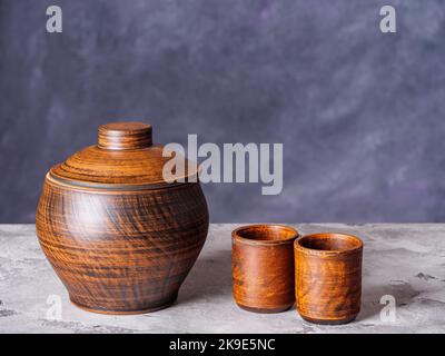 Clay pot and two empty ceramic cups on a grunge style background Stock Photo