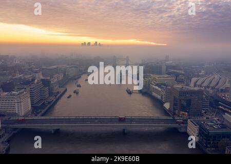 Aerial drone view of misty dawn sunrise over River Thames, London skyline at golden hour, City of London, UK Stock Photo