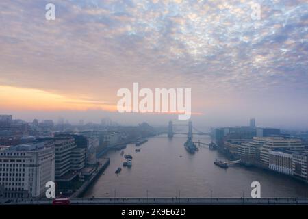 Misty dawn aerial drone view over River Thames and Tower Bridge, London skyline in morning mist, UK Stock Photo
