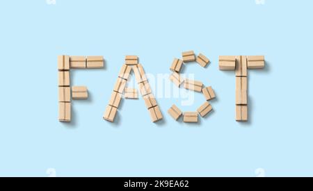 Word FAST made from cardboard boxes on a blue background. Stock Photo