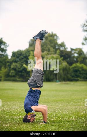 Dont have unhealthy habits turn your life upside down. a sporty middle-aged man doing a headstand. Stock Photo