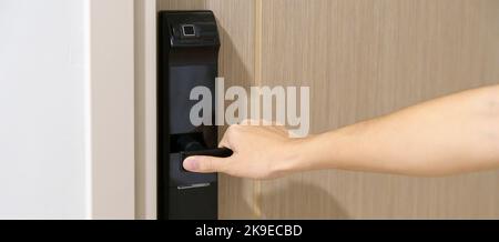 man holding handle of smart digital door lock while open or close the door. Technology, electrical and lifestyle concepts Stock Photo