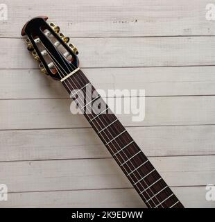 Acoustic guitar fretboard on wooden background. Space for text. Stock Photo