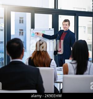 This is where well start focusing today. a young businessman giving a demonstration on a white board to his colleagues in a modern office. Stock Photo