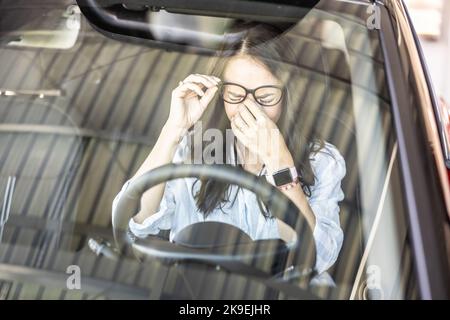 Tired female driver with glasses, needs a break to continue driving the car. Stock Photo