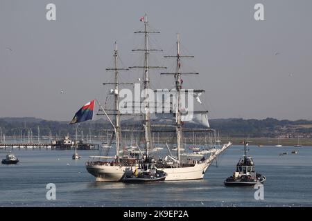 Tugs manoeuvre the Royal Oman Navy’s three mast square rigged clipper SHABAB OMAN II towards a berth in the Naval Base Stock Photo