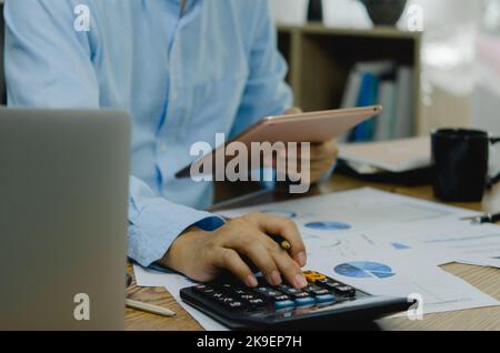 Businessman working at office with document on his desk.Paperwork graph report planning analyzing the financial and investment analysis concept. Stock Photo