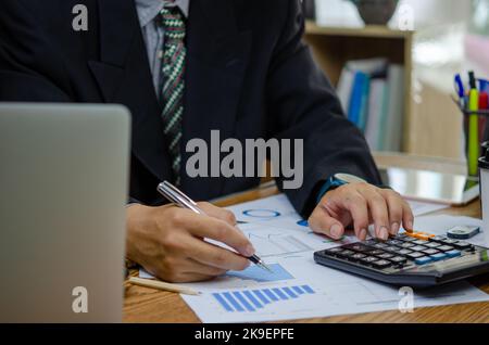 Businessman working at office with document on his desk.Paperwork graph report planning analyzing the financial and investment analysis concept. Stock Photo