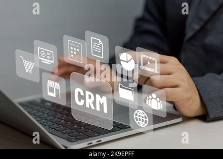 Hand typing on laptop concept. Icons CRM Customer Relationship Management business on virtual screen. Stock Photo