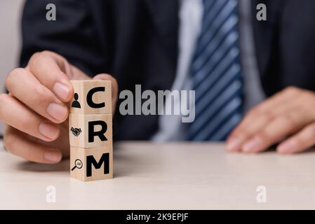 Wooden cubes with CRM Customer relationship management automation system software symbol on desk and copy space.Business concepts. Stock Photo