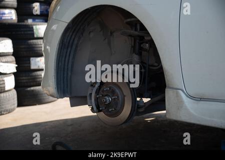 Change a car tire caused by a flat tire by using a jack to lift the car. Stock Photo