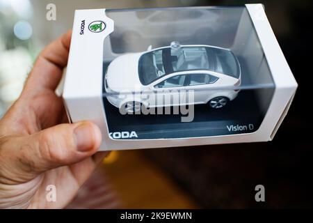London, United Kingdom - Oct 25, 2022: POV Male hand holding new Skoda Vision presentation for scale car model - view from above rooftop glass Stock Photo