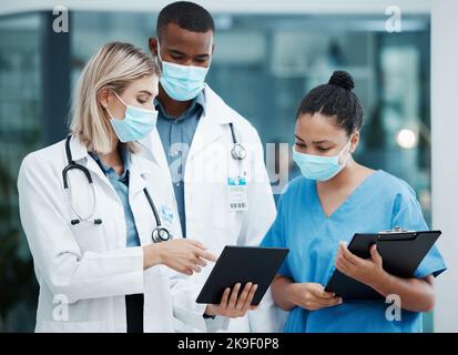 Doctor, tablet and covid team for healthcare, research or diagnosis in collaboration together at the hospital. Diverse group of medical professionals Stock Photo