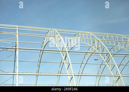 Basis for warehouse. Metal beams. Details of construction of sports complex. Steel details against blue sky. Stock Photo