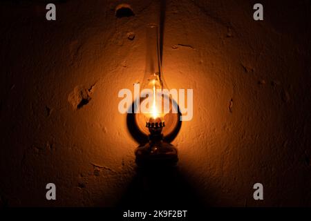 Kerosene lamp hanging on an old wall. Stock Photo
