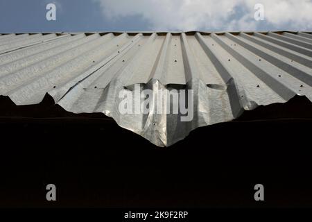 Dent on roof. Bent metal profile. Roof of building. Architectural details. Stock Photo
