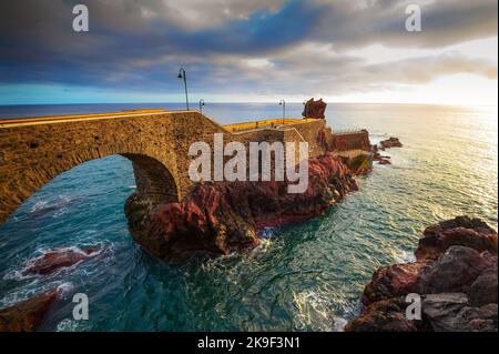 Sunset at the pier of Ponta do Sol in Madeira Island, Portugal Stock Photo