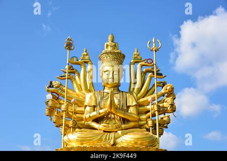 Big Golden Guan Yim or brass statue of Guanyin on a bright sky background. is the Goddess of Mercy and Compassion in the buddhist religion, much the s Stock Photo