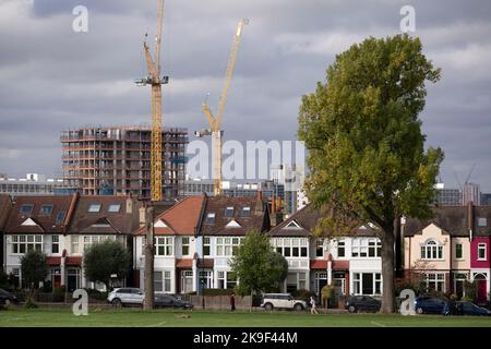 Residential London homes in the foreground and new high-rises under construction at Loughborough Junction, seen from Ruskin Park, a south London green space in Lambeth, on 6th October 2022, in London, England. Stock Photo