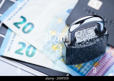 Closed padlock with money and credit card on laptop keyboard close up. Safe online banking or online shopping Stock Photo