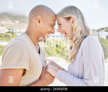 Beach, happy and interracial couple holding hands on holiday after marriage in Brazil together. Young, smile and man and woman with love on travel Stock Photo