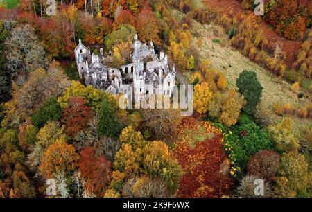 The ruins of Dunalastair House, near Pitlochry, Perthshire, are surrounded by trees displaying their autumn colours. Picture date: Friday October 28, 2022. Stock Photo