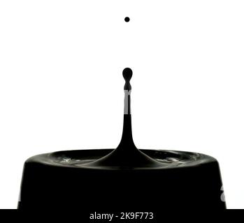 Black liquid drip, drop. Isolated on white. Could be oil or paint. Stock Photo