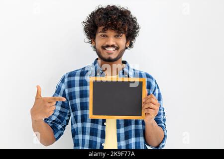 Portrait of young Asian man with chalkboard on white background. Male with curly hair holding a blank chalk board Stock Photo