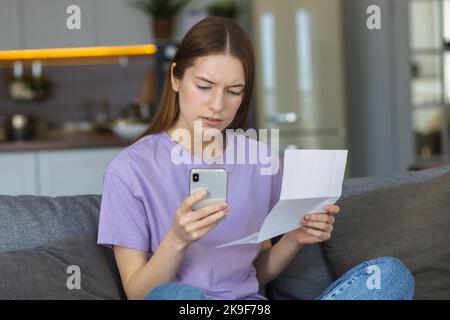 Woman holding bills in his hands and calculating payment. Family budget, paying taxes and bills, e-banking Stock Photo