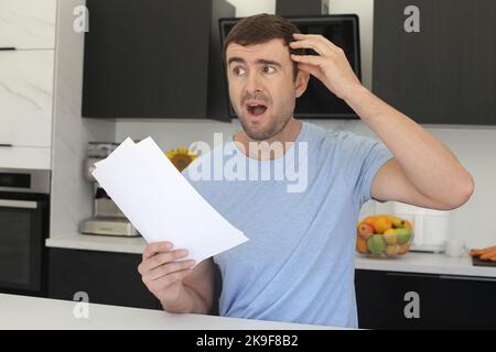 Stressed out man looking documents in the kitchen Stock Photo