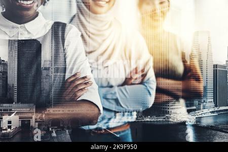 They are confident but also serious. a group of confident young businesswomen standing with their arms folded inside of the office at work. Stock Photo