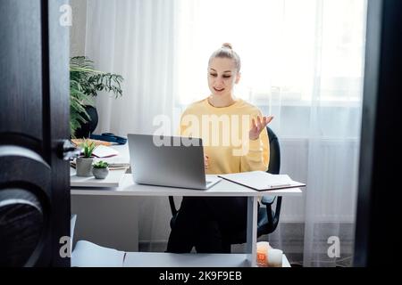 Tutoring, Homework Help, and Test preparation. Young woman speaking in front of camera for vlog as online tutor or couch. Earn extra money, money Stock Photo