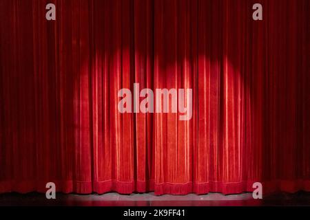Red curtains on a small theater, with a spotlight to the anticipation of the show. Stock Photo