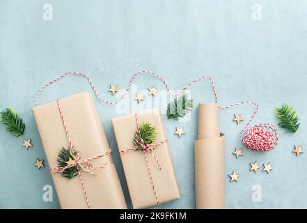 Gift wrapping with natural brown packing paper called Sack kraft paper or sack paper. Gifts decorated with red and white paper string. Stock Photo