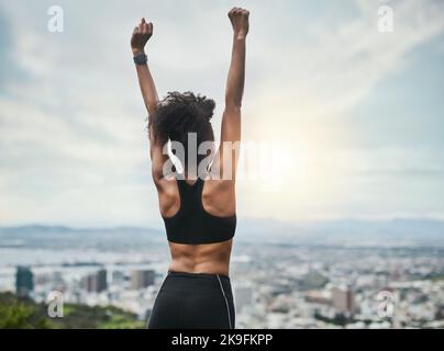 Doing the impossible. Rearview shot of an unrecognizable young sportswoman cheering in celebration outside. Stock Photo