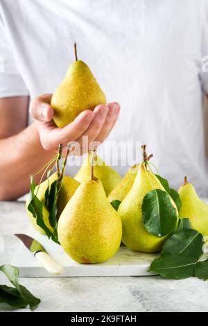 https://l450v.alamy.com/450v/2k9ftah/pears-fresh-sweet-organic-pears-with-leaves-on-stand-or-plate-and-in-the-background-male-hands-hold-pears-frame-of-autumn-harvest-fruits-top-view-2k9ftah.jpg