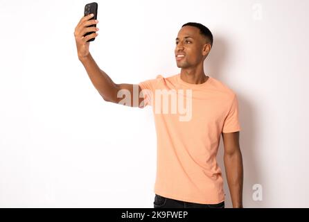 Smiling african american young man making selfie on white background Stock Photo
