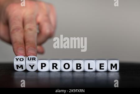 Hand turns dice and changes the expression 'my problem' to 'your problem'. Stock Photo