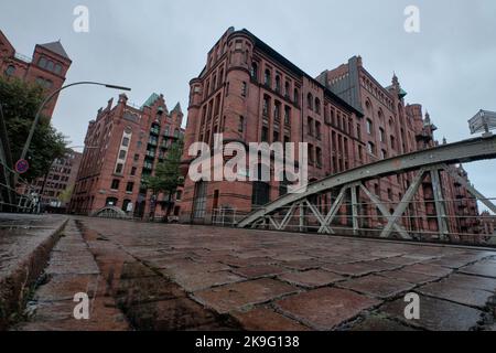 Hamburg, Germany - Sept 2022: Cobblestone pavement and arch bridge over canals in the Speicherstadt with old brick warehouse buildings Stock Photo