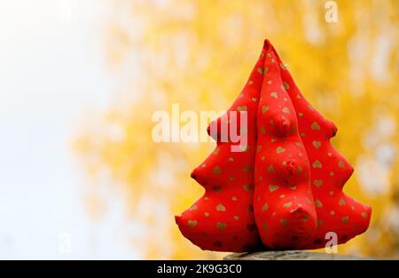 Red textile christmas tree with yellow background Stock Photo