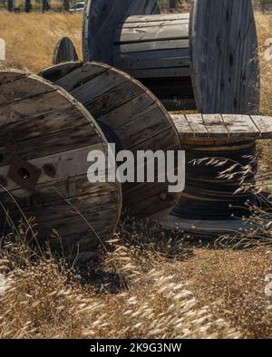 Heraklion, Crete, Greece - July 11 2021- Large wooden empty cable reels on a field Stock Photo
