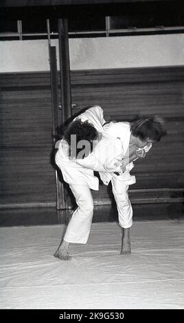 1970s, historical, inside, on a mat, two gmen competing in the sport of judo, a physical activity that involves two people wrestling and trying to throw each other to the ground Judo is a Japanese word meaning 'art of gentleness' and derives from the ancient Japanese martial art of jujitsu. Stock Photo