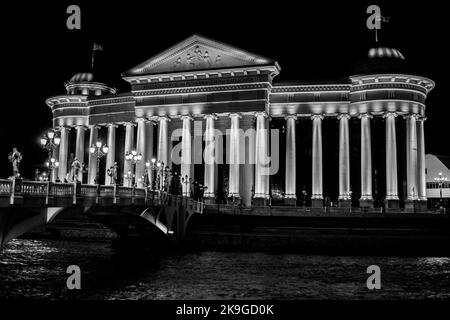 The Archaeological Museum of the Republic of Macedonia, built in neo-classical style, Skopje, North Macedonia. Next to the Vardar River bank at night. Stock Photo