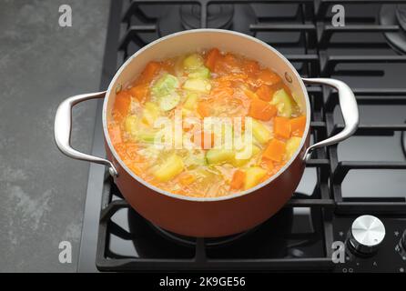 Boiling pot of pumpkin soup on gas stove top Stock Photo