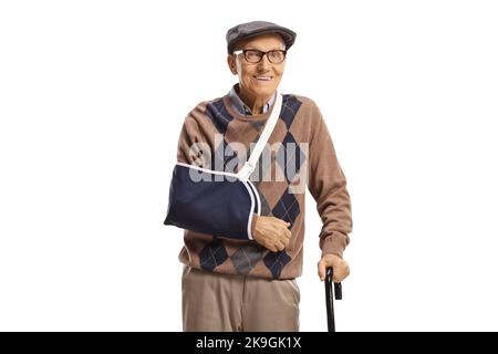 Smiling elderly man with a broken arm wearing a splint and standing with a cane isolated on white background Stock Photo